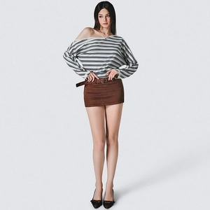 Detail of striped off-shoulder top with frayed neckline and brown suede mini skirt set