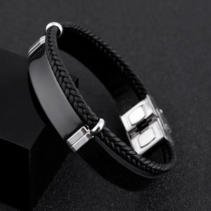 Detail view of woven black leather bracelet with polished metal plate and steel clasp