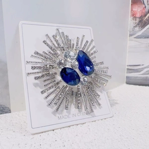 Detailed close-up of luxury sunflower brooch with blue gems and sparkling rhinestones