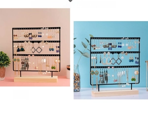 Detailed close-up of three-tier black metal earring display stand with a wooden base