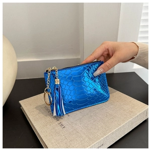Detail of metallic blue crocodile texture coin purse with tassel and gold zipper