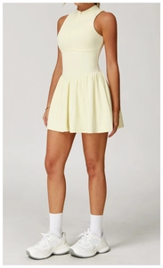Détail d'une robe de tennis sans manches jaune clair avec jupe plissée et col montant