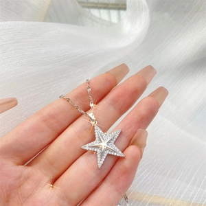 Collier élégant avec pendentif étoile pavé de zircons, présenté sur la main