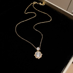 Detail of 14k gold plated starburst pendant necklace with cubic zirconia on black velvet