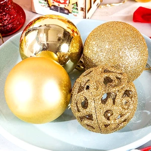 Detail view of gold Christmas ornaments with matte, glitter, and hollow textures
