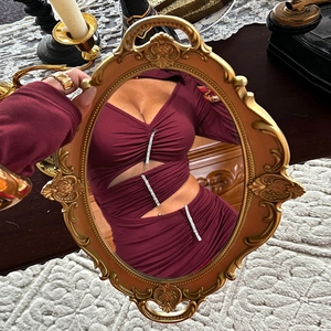 Details des burgunderroten Cut-out-Kleids mit Strasskette im Vintage-Spiegel