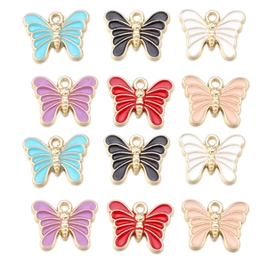 Macro shot of twelve colorful enamel butterfly pendants with golden alloy frames for DIY