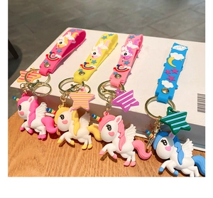 Detail of four colorful PVC unicorn keychains with matching wrist straps and star charms