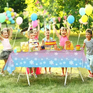 Outdoor birthday party scene with gradient snowflake tablecloth and colorful balloons