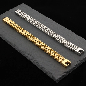 Dual-tone gold and silver stainless steel dragon bone chain bracelets on slate stone