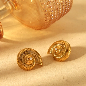 18k gold plated stainless steel nautilus earrings with pearls on textured beige fabric