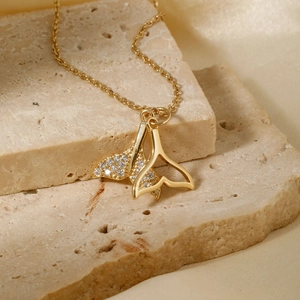 Elegant gold double whale tail necklace with clear zircon inlay on silk background