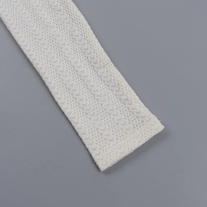 Gros plan sur la texture dentelle blanche et le tissu en maille ajouré du haut chic