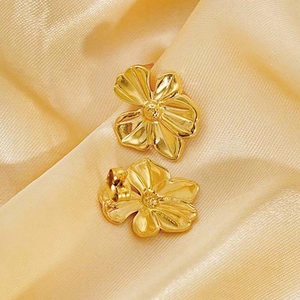 Elegant gold flower stud earrings displayed on smooth silk fabric for jewelry set