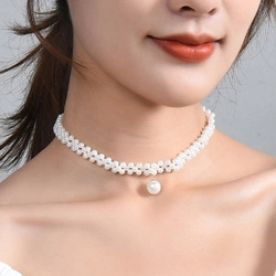 Detail of multi-row white pearl choker with a single large pearl drop pendant