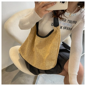 Mirror selfie showing khaki hollow woven hobo bag with black leather straps and trim
