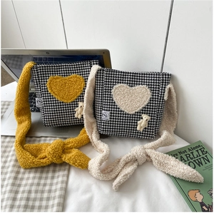 Détail du sac bandoulière en peluche pied-de-poule avec motifs cœurs et ourson