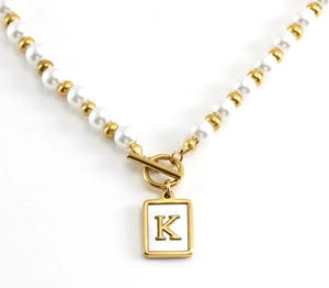 Detail shot of pearl necklace with gold OT clasp and rectangular letter K pendant