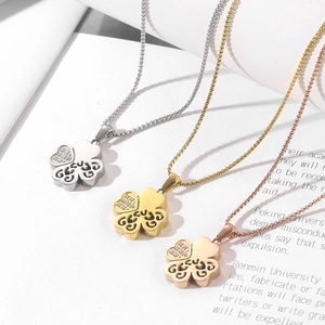 Close-up of heart-shaped four-leaf clover necklaces in silver, gold, and rose gold finishes