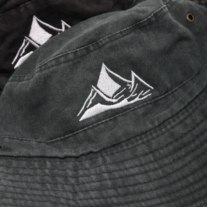 Detail of mountain embroidery on washed black cotton outdoor hat with metal eyelets