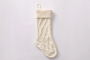 Macro shot of white cable knit Christmas stocking showing detailed woven textures