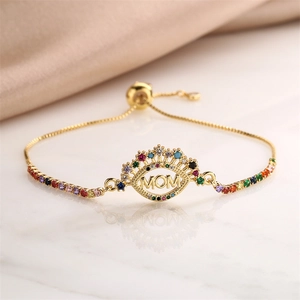 Detail of gold MOM adjustable bracelet featuring colorful pavé zircons and silk backdrop