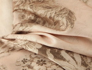 Vue macro de l'imprimé floral doré sur tissu en satin de luxe à texture soie