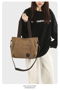 Detail of coffee brown canvas messenger bag with leather logo and multi-pocket design