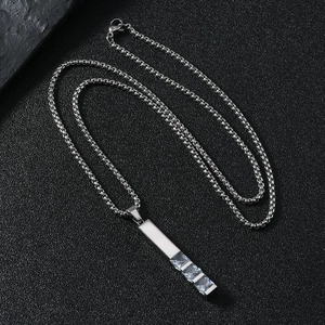 Macro shot of silver stainless steel pendant necklace with three square zircon stones