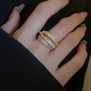 Detailed view of layered gold-tone ring with sparkling cubic zirconia on a female finger