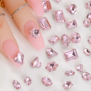 Macro view of assorted pink crystal nail art rhinestones in various shapes and sizes