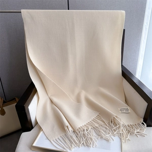 Close-up of beige cashmere blend scarf with elegant tassels and Underson brand label