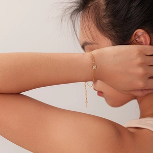 Detail von 18K vergoldetem Edelstahl-Armband mit quadratischem Zirkonia-Anhänger am Handgelenk