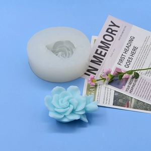 Détail du moule en silicone rose 3D avec bougie fleur bleue sur fond bleu clair