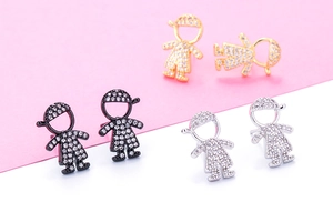 Detailed view of zircon-studded boy-shaped earrings in gold, black, and silver finishes