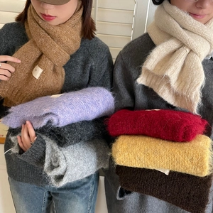 Close-up of soft knitted wool scarves in various solid colors like camel and beige