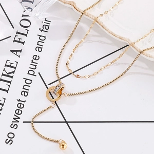 Detail of a double-layered gold necklace featuring rhinestone rings and adjustable chain