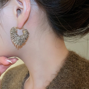 Close-up of model wearing C-shaped crystal beaded hoop earrings with champagne beads