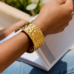 Detail of 18k gold plated stainless steel hammered texture cuff bracelet on wrist