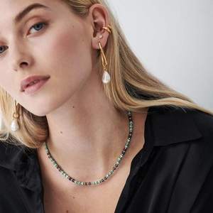 Detail of beaded necklace with turquoise stones and gold earrings with baroque pearls