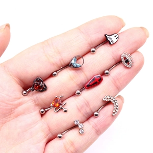 Detailed view of punk hip-hop eyebrow piercings with heart and devil zircon designs on palm