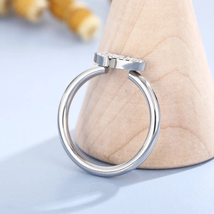 Macro shot of silver heart ring with micro-pave crystals on wooden display stand