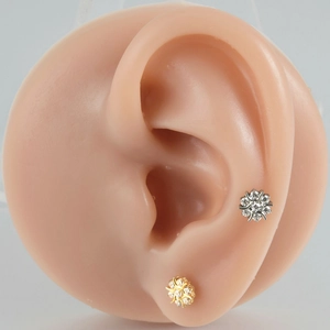 Sparkling snowflake labret studs in F-136 titanium alloy on a realistic ear model