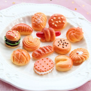 Miniature resin food models including croissants and burgers on a white embossed plate