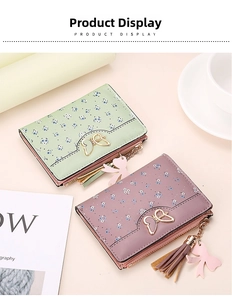 Detail of floral trifold wallets in mint green and mauve with golden butterfly buckles
