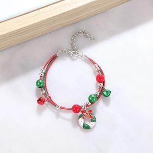 Detail of Christmas beaded bracelet featuring bells, wreath charm and woven rope