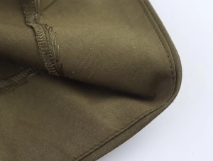 Gros plan sur une robe midi kaki montrant la couture précise et la texture du tissu