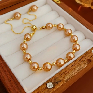 Detail of champagne pearl bracelet with adjustable gold chain in a wooden jewelry box
