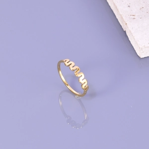 Bague minimalist en acier titane doré au design ondulé sur une surface réfléchissante