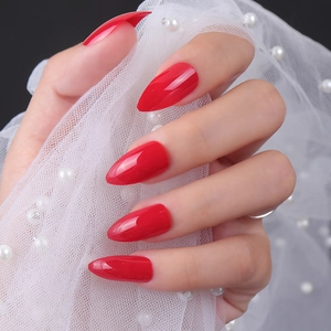 Close-up of shiny red stiletto false nails with high gloss finish on pearl mesh background
